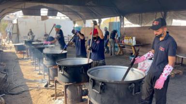 Cooks stir pots of rice and lentils at a community food kitchen run by the US-based humanitarian organisation Anera in Khan Younis, southern Gaza