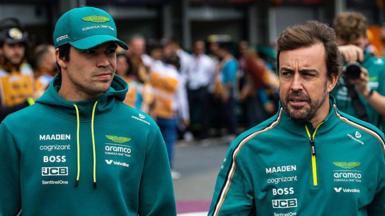Lance Stroll and Fernando Alonso walk in the pit lane
