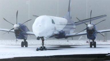 The nose of an aeroplane is covered in snow during wintry conditions while sitting on the tarmac at Humberside airport in Lincolnshire in 2012.