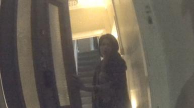 Woman opening a front door to a house