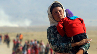 Woman with children fleeing Sinjar after IS attack in 2014