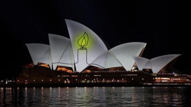 The image of a candle lit up on the Opera House sails