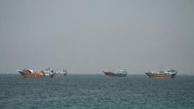 Four large boats drifting on the Strait of Hormuz as seen from Oman.