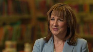 Chancellor Rachel Reeves, sitting down being interviewed, wearing a light blue suit jacket