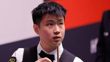 Zhao Xintong looks at a shot