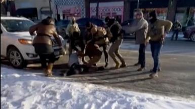 Federal agents are standing around a man on the ground