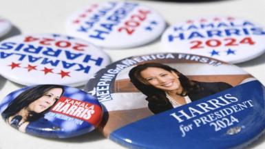 A close up of US Election badges showing Kamala Harris on a white tabletop