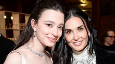 Mikey Madison and Demi Moore in evening dress, smiling with their heads close together