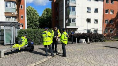 Police officers stood outside a university building. 