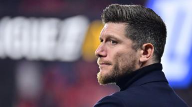 Sebastien Pocognoli, pictured wearing a roll neck top, looks across to his left