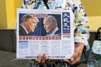 A newspaper vendor in Hong Kong, China, distributes a daily featuring coverage of the US presidential debate