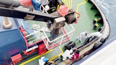 officials in hazmat suits on a small boat