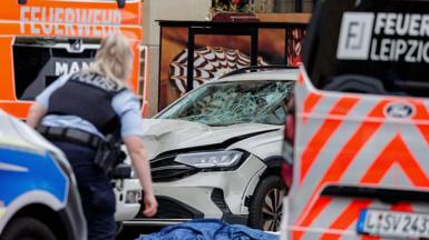 a police officer in front of a damaged car