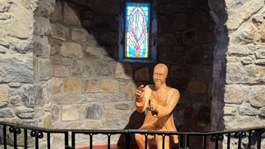 An ìomhaigh agus uinneag dhathte air a cùlaibh