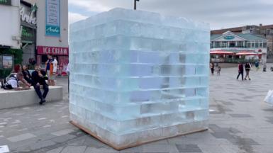 A large block of ice next to a building.