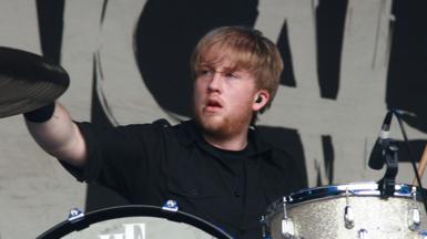 Bryar sitting behind a set of drums looking off to one side as he drums at the Sydney leg of the Big Day Out Festival in January 2007 