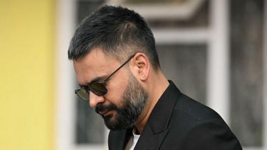 Balen Shah wears dark sunglasses and a dark jacket and white T-shirt