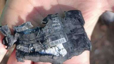 A hand shows a destroyed pager 