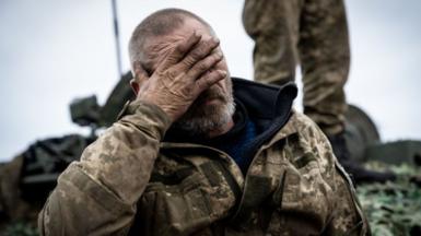 A Ukrainian soldier with the nickname Dragon shows the fatigue of months of fighting without a break, as the rest of the tank crew make adjustments to a captured Russian T-72B tank, as they drive it toward the northeastern Kharkiv region frontline on a road to Izyum, Ukraine, on September 28, 2022
