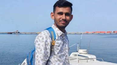 Sunil Puniya stands on the shore next to a boat in the left hand image. In the right hand image the Skylight is seen in the distance on fire with plumes of black smoke billowing into the sky.