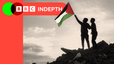  A boy runs with a Palestinian flag atop a mound of rubble at a camp