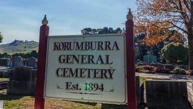 Sign of Korumburra General Cemetery Est. 1984 with headstones in the backgound