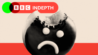 A donut with an unhappy face iced on to it