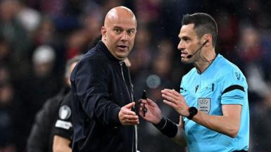 Liverpool manager Arne Slot speaks to referee Maurizio Mariani during the Champions League quarter-final second leg against Paris St-Germain