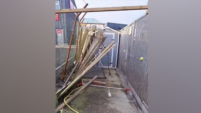 A wooden fence is mangled and barely holding together.