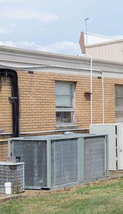 The picture of the side of a building with an air conditioning unit