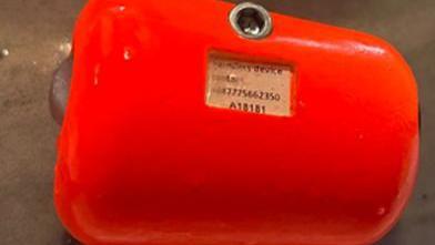 One of the tags. It is bright red and has a label which has a series of numbers on it and there is a hole above it.