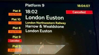 A railway station information departures/arrivals display showing that the 18:02 for London Euston has been cancelled
