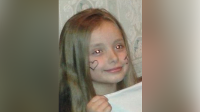 Milly as a child with a love heart painted on her face