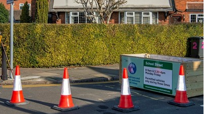 School street restrictions Knighton. Traffic cones are pictured on a street with a house in the background