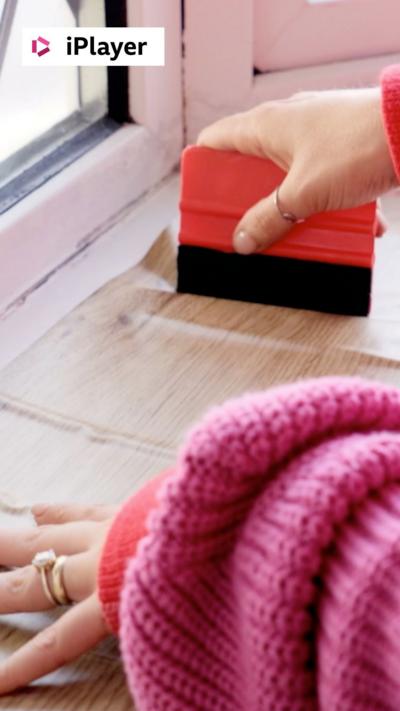 Two hands holding a piece of vinyl on a windowsill 