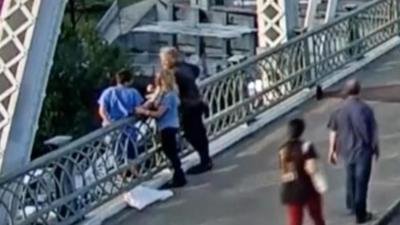 Jon Bon Jovi and a member of his team speak with a woman in distress