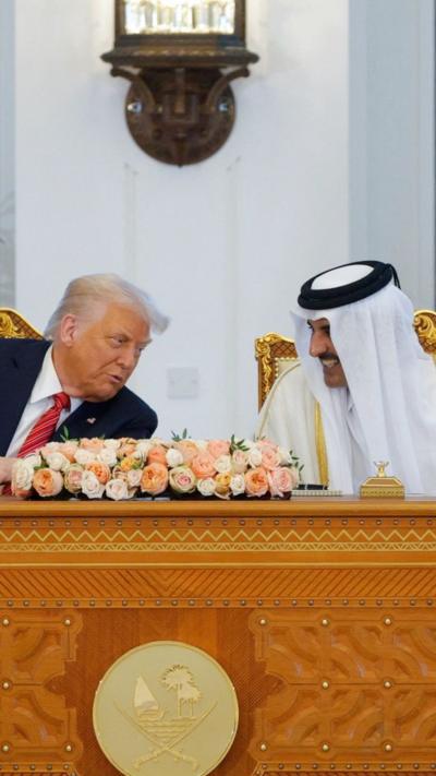 Trump and Emir of Qatar pictured at a table during signing ceremony