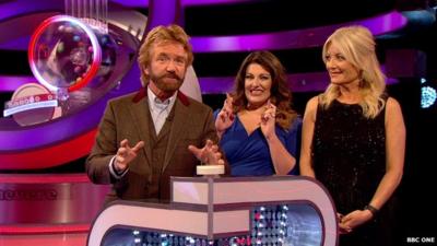 Noel Edmonds prepares to push the lottery draw button