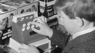 Boy plays with a toy cash register