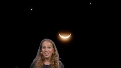 Sophia Herod stands in front of a 'smiley face' made up of Venus, Saturn and the Moon