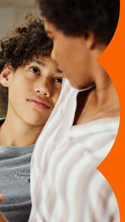 Stock image of a child in his mother's arms, looking upset