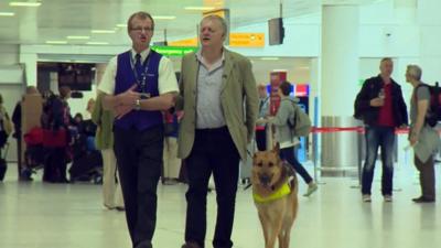 Ian and his guide dog are assisted in Glasgow airport