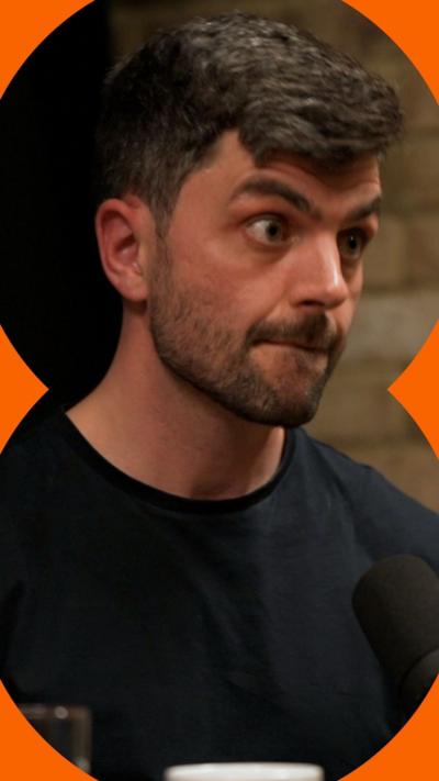 Man with short dark hair wearing a black t-shirt.