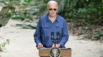 Biden stands in front of the podium.