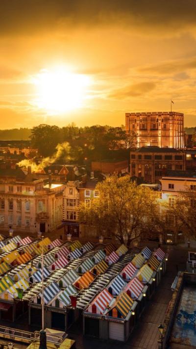 Norwich market and castle at sunset bathed in golden light