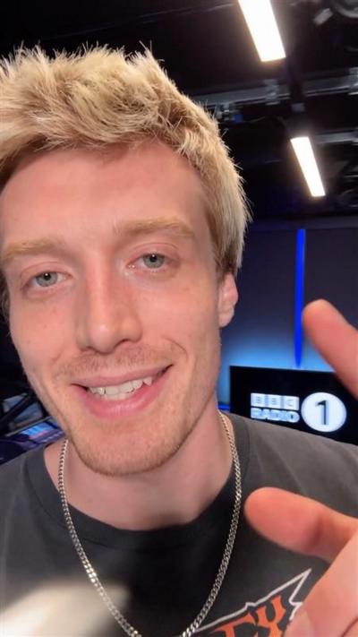 Jack Saunders talking to camera with Radio 1 studio behind him