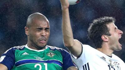 Northern Ireland's Josh Magennis battles with Germany's Thomas Muller in Hanover