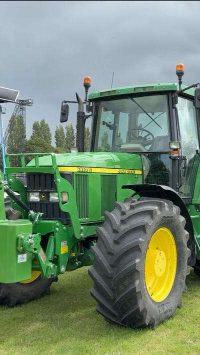 The image is of a green tractor with yellow wheels.