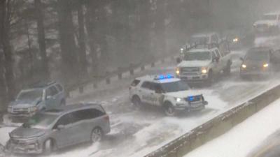 Numerous cars that are hit are on the highway after massive pileup because of the snow.