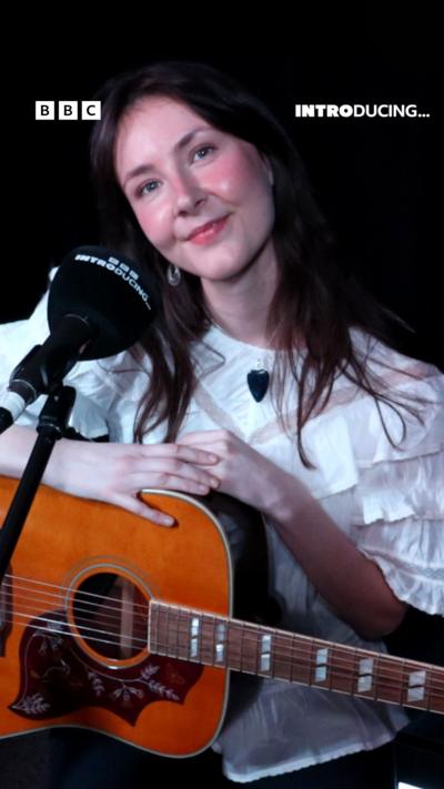 A woman with a guitar.